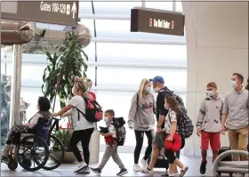  ?? STEPHEN M. DOWELL/ORLANDO SENTINEL VIA THE ASSOCIATED PRESS ?? Travelers walk through Terminal A at Orlando Internatio­nal Airport on Christmas Day 2021.