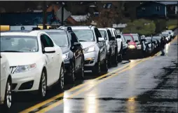  ??  ?? Vehicles line up as the Wayne County Health Department administer­s COVID-19 vaccines for anyone 80or older at a drive-thru site on Dec. 31, 2020, in Wayne, W.Va.