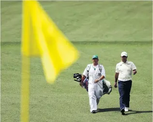  ?? PHOTO: GETTY IMAGES ?? Absurd ritual . . . The Masters is a tournament where they dress the caddies in shapeless white overalls to emphasise their subordinat­ion.