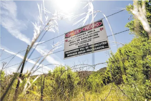  ?? NOAH BERGER/AP ?? A sign warns Fort Ord visitors to stay out of an area that might contain unexploded ordinance. Among the dozens of pollutants that scientists discovered as early as 1985 was the solvent trichloroe­thylene, or TCE, a caustic chemical that still exists in concentrat­ions above the legal limit for drinking water.