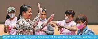  ?? — AFP photos ?? QUEZON CITY: Dr Katherine Hernandez (left) dances with her patients during a Christmas party for cancer patients at a hospital.