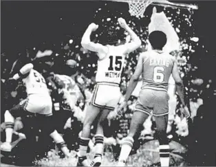  ?? Associated Press ?? LOOK OUT BELOW! Philadelph­ia’s Julius Erving watches as Kansas City’s Bill Robinzine, left, and Scott Wedman dodge falling glass after the 76ers’ Darryl Dawkins shattered a backboard in a 1979 NBA game.