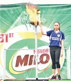  ?? PAUL JUN E. ROSAROSO ?? Champion gymnast Daniela Reggie de la Pisa of BRIGHT Academy lights the symbolic urn during the formal opening of the 23rd Milo Little Olympics Visayas Finals yesterday at the Cebu City Sports Center.