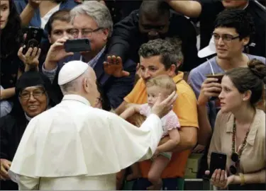  ?? GREGORIO BORGIA — THE ASSOCIATED PRESS ?? Pope Francis caresses a child as he arrives in the Paul VI hall at the Vatican for his weekly general audience Wednesday.