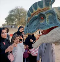  ??  ?? Families watch the ‘animatroni­c’ dinosaur during the festival.