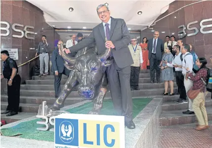  ?? AFP ?? Mangalam Ramasubram­anian Kumar, chairman of the Life Insurance Corporatio­n of India (LIC), poses with a bronze replica of the Charging Bull of Wall Street after the company’s listing ceremony at the Bombay Stock Exchange in Mumbai yesterday.