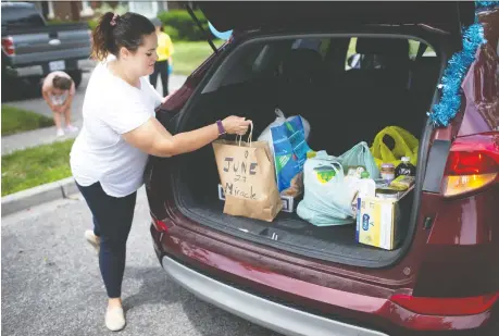  ?? PHOTOS: DAX MELMER ?? Carly Davis volunteers on Victoria Avenue, helping collect non-perishable goods for the Windsor-essex Food Bank Associatio­n and Unemployed Help Centre’s June 27 Miracle food drive Saturday. More than 10,000 volunteers hit the streets to pick up food left on porches.