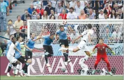  ?? The Associated Press ?? France’s Raphael Varane, second right, scores his side’s first goal against Uruguay during a quarterfin­al match in Nizhny Novgorod, Russia, on Friday.