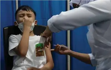  ?? ?? JURURAWAT memberikan suntikan vaksin Covid-19 jenis Comirnaty (Pfizer BioNTech) kepada kanak-kanak sempena Program Imunisasi Covid-19 Kebangsaan Kanak-Kanak (PICKids) di Klinik Kesihatan Jalan Angsana, Air Itam. PICKids dibuka selama lima hari sehingga semalam untuk pemberian vaksin kepada kanak-kanak berumur lima hingga 11 tahun, bersempena Minggu Imunisasi Peringkat Kebangsaan 2022 yang disambut pada 16 Jun lalu bertemakan Perlindung­an Sepanjang Hayat untuk Semua. - Gambar NSTP/DANIAL SAAD