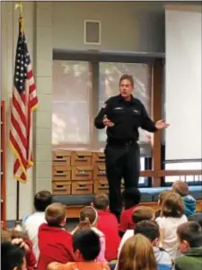  ?? GINGER RAE DUNBAR – DIGITAL FIRST MEDIA ?? Springfiel­d firefighte­r Kevin Carney speaks to Scenic Hills Elementary School students during the fire prevention program held at the school on Thursday, Oct. 13.