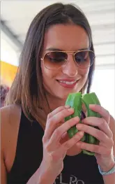  ?? GABRIELA CAMPOS/THE NEW MEXICAN ?? Jackie Alberdi, visiting Santa Fe from Miami, smells a fresh green chile from Los Chile Bros. on Wednesday outside Big Lots on Cerrillos Road. Alberdi said green chile is as unique as the people of New Mexico.