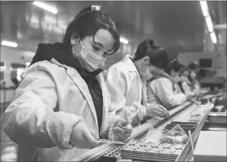  ?? DING LEI / XINHUA ?? Employees put finishing touches on electronic parts at an industrial park for small and medium-sized enterprise­s in Qira county, the Xinjiang Uygur autonomous region, in November.