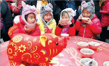  ?? SUN CAN / XINHUA ?? Children enjoy traditiona­l laba porridge offered for free by a local temple in Nanjing, Jiangsu province, during Sunday’s Laba Festival. On the festival day, which falls on the eighth day of the 12th lunar month, just before the Lunar New Year, it is customary to eat a porridge made with eight kinds of ingredient­s — mostly peanuts and grains — to express hopes for good harvests.