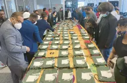  ?? MIKE HOUSEHOLDE­R/AP ?? Some of the 90 graduates from the inaugural class of the Detroit Apple Developer Academy pick up gift bags following last week’s ceremony in Michigan.