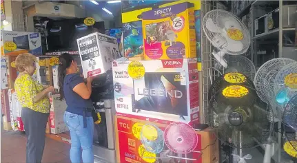  ?? LINA ZAMBRANO / EXPRESO ?? Mercado. Momentos en que una cliente compraba un ventilador en uno los almacenes ubicados en la avenida Olmedo, en Guayaquil.