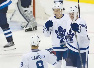  ?? The Canadian Press ?? Toronto Maple Leafs forward Auston Matthews, right, celebrates his goal against the Winnipeg Jets with teammates Connor Carrick and William Nylander during third-period NHL action in Winnipeg on Wednesday. The Leafs won 7-2.