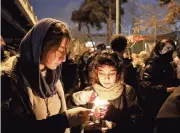  ?? EBRAHIM NOROOZI AP ?? In Tehran, Iran, people gather for a candleligh­t vigil Saturday at the gate of Amri Kabir University to remember the victims of the Ukraine plane crash.