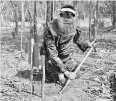  ??  ?? A demining team member checks for unexploded ordinances. — Bernama photo