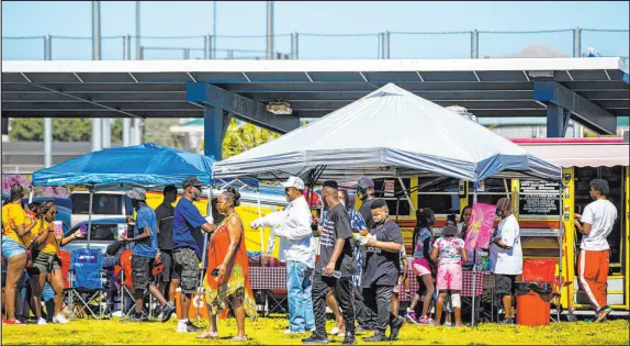  ?? Chase Stevens Las Vegas Review-Journal ?? People check out vendors during a 2020 Juneteenth event held by Save Our Sons at Lorenzi Park.