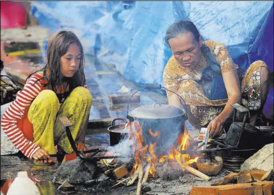  ?? Romeo Ranoco Reuters ?? Evacuees cook food Saturday in Lanao del Sur, Philippine­s. The government is battling Islamic militants on the island of Mindanao.