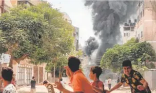  ?? // AFP ?? Palestinos corren ayer durante un bombardeo de Israel a Gaza
