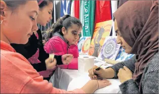  ?? JUANITA MERCER/THE TELEGRAM ?? Raahyma Ahmad applies henna tattoos at the multicultu­ral festival at the Macmorran Community Centre in St. John’s on Thursday.