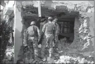  ?? AP/MOHAMMAD ANWAR DANISHYAR ?? Afghan security forces inspect a bombed-out building after an attack Wednesday on the Pakistani Consulate in Jalalabad.