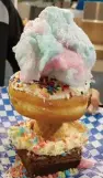  ??  ?? The Sugar Mountain is made of a brownie and cheesecake base, with a sugar cone plus a doughnut and cotton candy.