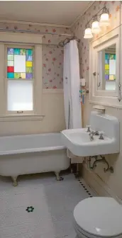  ??  ?? bottom left The upstairs bath retains its clawfoot tub, art-glass window and casings, and beadboard wainscot. The wall-hung sink is 1920s salvage. The floor was painted with a stencil to look like hex tile.