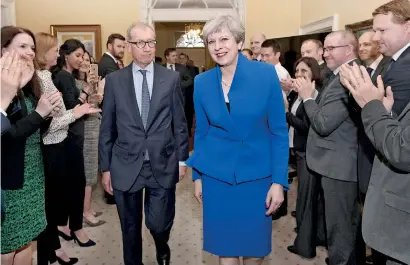  ??  ?? Britain's Prime Minister Theresa May and her husband Philip are welcomed by staff inside 10 Downing Street, in London, Britain. REUTERS/Stefan Rousseau