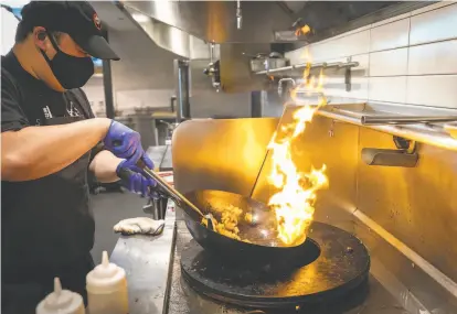  ??  ?? Kevin Tang fries king trumpet mushrooms at Claws of Mantis, which started as a pandemic side hustle.