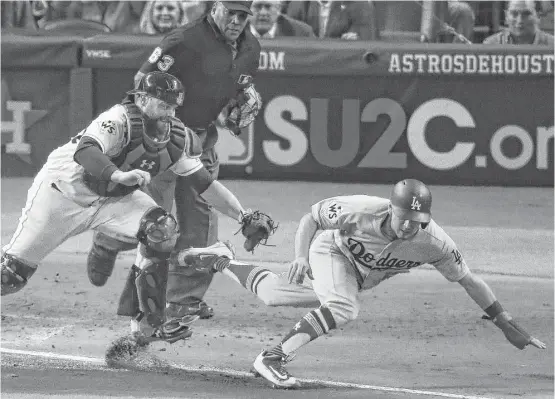  ?? Michael Ciaglo / Houston Chronicle ?? Astros catcher Brian McCann (16) chases down Dodgers catcher Austin Barnes, preventing a run in the sixth and keeping it scoreless until the bottom of the inning.