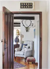  ??  ?? Hallway The kitchen door, with the original Twenties servants’ bells above, leads to a hall featuring a painted skull by Karen’s artist brother, Douglas Moffat. Skull, Skulldougg­ery. Similar chair, Denbigh, Laura Ashley. Similar footstool, Red Tribal, Myakka.