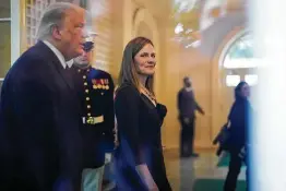  ?? Washington Post file photo ?? Federal appeals court judge Amy Coney Barrett walks with President Donald Trump after he announced her nomination to the Supreme Court on Sept. 26.