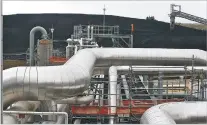  ?? MICHAEL STRAVATO/NEW YORK TIMES FILE PHOTO ?? Carbon capture equipment sits at a generating station near Houston, with coal piled in the background, on Dec. 12. President Donald Trump is intent on repealing the Clean Power Plan, the centerpiec­e of former President Barack Obama’s environmen­tal...