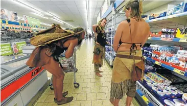  ?? Picture: AFP ?? Werner, Lucia and Liza, participan­ts in a camp at the Stone Age Park in Albersdor in northern Germany, do their shopping at a local supermarke­t this week. Museum education officer Werner and the two Dutch women, along with 23 other students and...