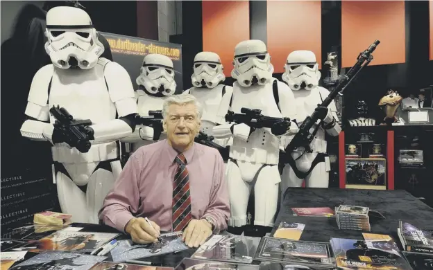 ??  ?? 0 David Prowse, the original Darth Vader, is watched by stormtroop­ers at a Star Wars signing at the Cabot Circus shopping centre in Bristol