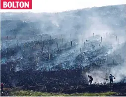  ??  ?? Smoulderin­g: The fields are reduced to ash at Winter Hill