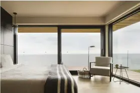  ??  ?? BELOW RIGHT: The second-floor master bedroom appears to float over the seascape outside, highlighti­ng the home’s earth-meets-sky dynamic.