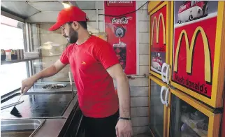  ?? VAHID SALEMI/THE ASSOCIATED PRESS ?? A knock-off version of McDonald’s — Mash Donald’s — exists in Tehran, selling burgers and fries, and its owner welcomes potential competitio­n from McDonald’s Corp.