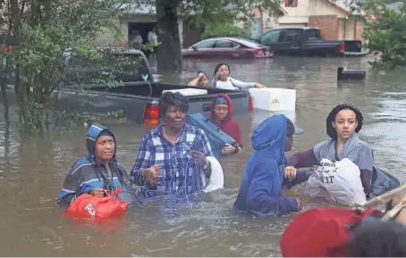  ?? JOE RAEDLE/GETTY IMAGES ?? Houston residents evacuate their homes amid rising floodwater­s and persistent heavy rain from Tropical Storm Harvey.