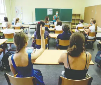  ?? FABRIZIO BENSCH / REUTERS ?? Students at a high school in Berlin, Germany, wear face masks during a lesson
on their first day back after the summer holidays earlier this month.