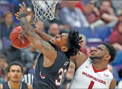  ?? Associated Press ?? Defense: South Carolina's Chris Silva (30) has the ball knocked away by Arkansas' Trey Thompson (1) during the first half of their game at the Southeaste­rn Conference Tournament Thursday in St. Louis.