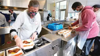  ?? AP PHOTOS ?? Volunteers Sheeran Howard (left) and Ibrahim Bahrr package meals at Community Servings in Boston’s Jamaica Plain neighborho­od. Insurers first started covering Community Servings meals about five years ago, and CEO David Waters says they now cover close to 40%. LEFT: Hundreds of containers of soup are prepared for clients at Community Servings, which prepares and delivers scratch-made, medically tailored meals to people with critical and chronic illnesses.