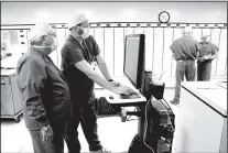  ?? Staff Photo by Tim Barber ?? Registered nurses Dan Phillips, left, and Tom McDonald enter informatio­n into a patient tracking system in the surgery center at Memorial Hospital. Memorial has plans for 700 new positions following the constructi­on of an expansion including operating rooms.