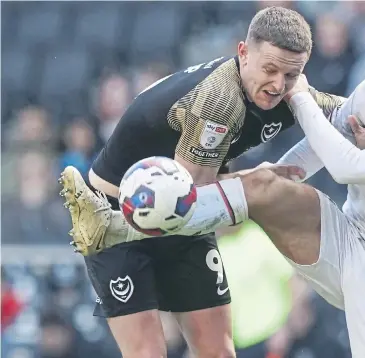  ?? ?? Pompey striker Colby Bishop gets some rough treatment at the hands of MK Dons defender Jack Tucker during