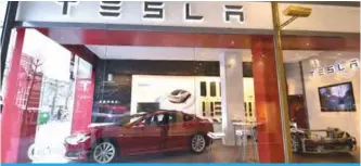  ?? —AFP ?? BRUSSELS: A Tesla Model S car by US car maker Tesla is displayed at a store.