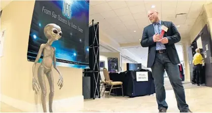  ?? JORDAN KRUMBINE/STAFF PHOTOGRAPH­ER ?? Mutual UFO Network state director Morgan Beall stands alongside an alien statue that welcomed mankind to the annual MUFON symposium in Lake Buena Vista.