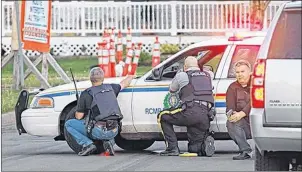  ?? (THE GUARDIAN FILE PHOTO) ?? RCMP officers take cover behind their vehicles in Moncton, N.B. on Wednesday June 3, 2014. Three officers were killed in the shootout by a man armed with a rifle, while out-gunned police were largely restricted to handguns.