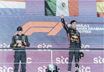  ?? /EFE. ?? Mientras Sergio Pérez (der.) celebraba sonriente su triunfo en el Gran Premio de Arabia Saudita, su compañero, Max Verstappen (izq.), se mostró indiferent­e en el podio.